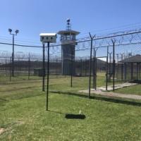 Prison yard with barbed wire fences and guard tower