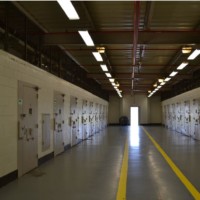 Hallway with rows of locked segregation cell doors on either side