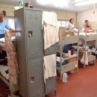 Female prisoners seated on bunk beds