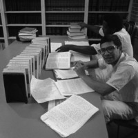 Two prisoners sit in law library in front of books and handwritten briefs