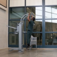 A prisoner does pull-ups on an exercise machine