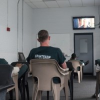 A few prisoners watch TV in medium size recreation room