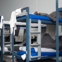 One detainee lies on the bottom bunk of his dorm bed